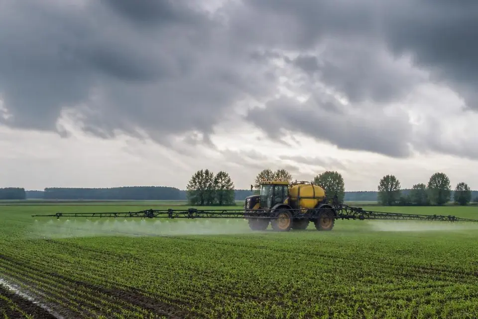 Lauko purkštuvas purškia pasėlį prieš lietų debesuotą dieną Lietuvoje